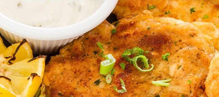 Charleston crab cake with lemon wedges and remoulade